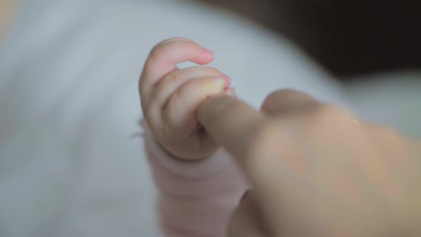 Маленькая дочь держит мамин палец — стоковое видео