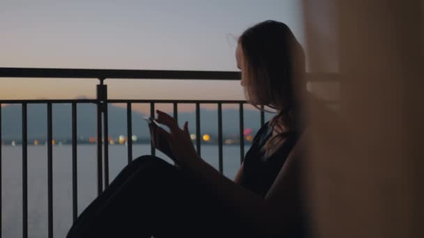 Mujer con tablet PC en el balcón con vistas al mar — Vídeo de stock