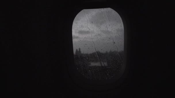 Flying by plane in rainy evening, view through the illuminator — Stock Video