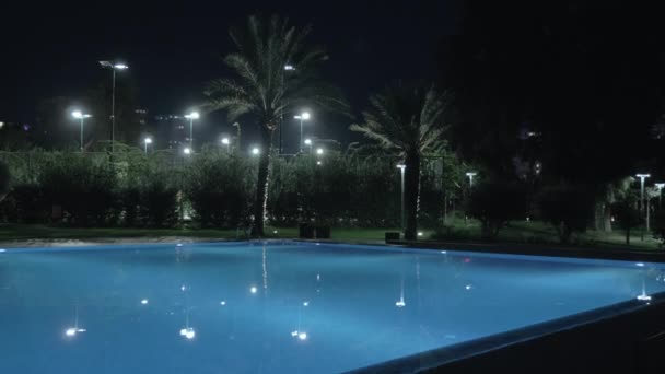 Vista nocturna de la piscina en el complejo — Vídeo de stock