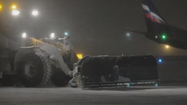 Tractor snow plow in the airport at night — Stock Video