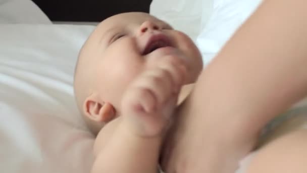 Ребенок смеется, когда мама делает массаж — стоковое видео