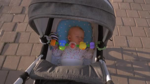 Baby girl sleeping during outdoor walk in pram — Stock Video