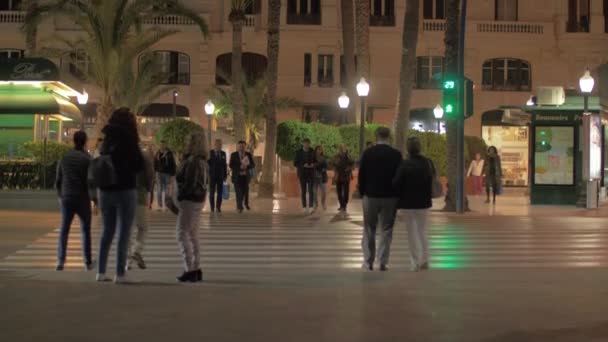 Улица вечером Аликанте, Испания. Люди, переходящие дорогу — стоковое видео