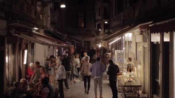 W nocy Wenecja, Włochy. Ulica z chodzeniem ludzi i kawiarni na świeżym powietrzu — Wideo stockowe