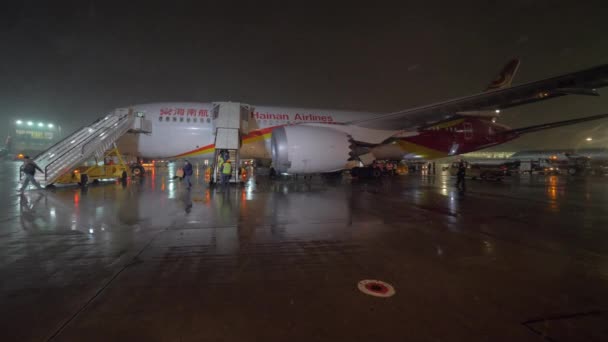 Pasajeros que desembarcan en el avión de Hainan Airlines por las escaleras aéreas por la noche — Vídeo de stock