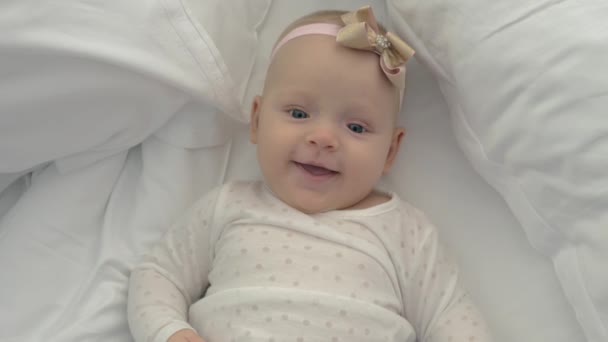 Lachende blauwogige babymeisje met strik — Stockvideo