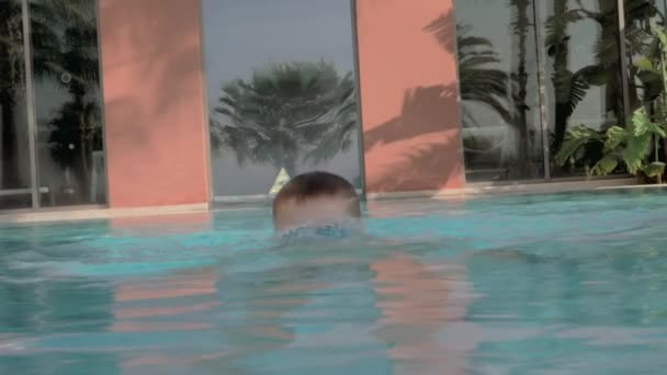 Bimbo in piscina all'aperto. Si tuffa e viene in superficie — Video Stock