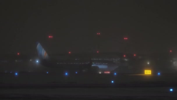 Avião Flydubai na pista no aeroporto noturno no inverno — Vídeo de Stock