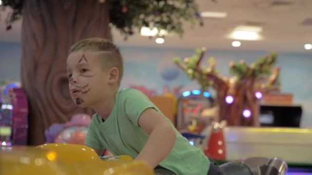 Дитину приваблює гоночний симулятор в парку розваг — стокове відео