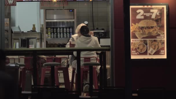Oma en kleinkind fastfood eten, bekijken door café raam — Stockvideo
