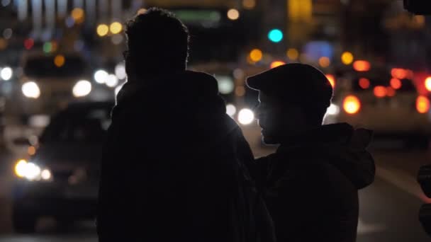 Trafikkflyt og folk som venter på grønt trafikklys i byen om natten – stockvideo