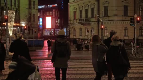 Люди переходят дорогу в ночном городе. Хелли, Финляндия — стоковое видео