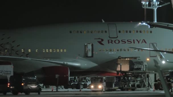 Vista nocturna del avión Rossiya en preparación para el vuelo. Aeropuerto de Vnukovo en Moscú — Vídeo de stock