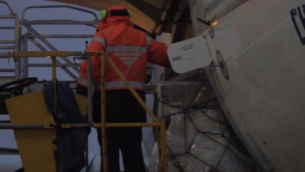 Un trabajador del aeropuerto en el ascensor observando la entrega de carga — Vídeos de Stock