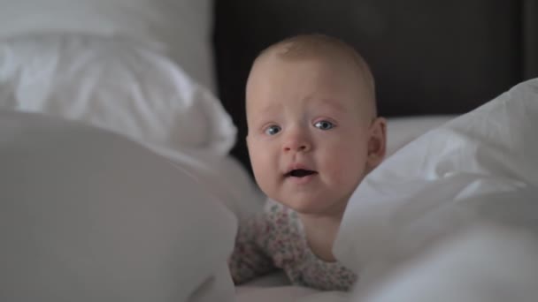 Un primer plano de una linda niña en sábanas blancas — Vídeo de stock