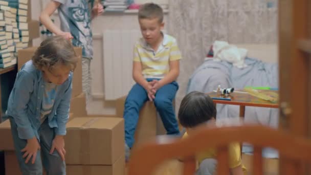 Grupo de niños jugando entre cajas en casa — Vídeos de Stock