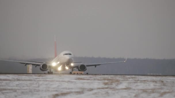 Vliegtuig vertrek op een besneeuwde baan — Stockvideo