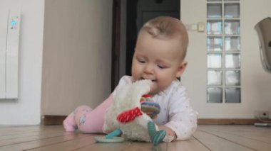Bir ahşap zemin üzerinde oynayan kız bebek
