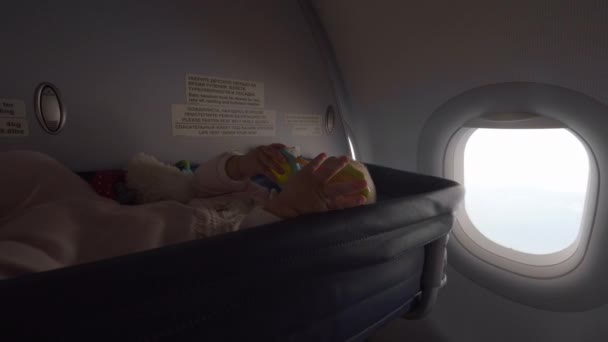 Baby in a cot bassinet on an airplane — Stock Video