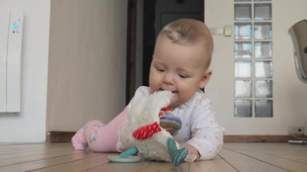 Meisje van de baby spelen op een houten vloer — Stockvideo