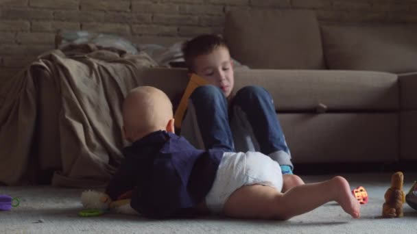 Baby krabbelt in Nähe des Bruders — Stockvideo