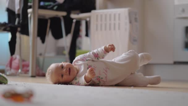 Adorable niña acostada de lado en la alfombra — Vídeos de Stock