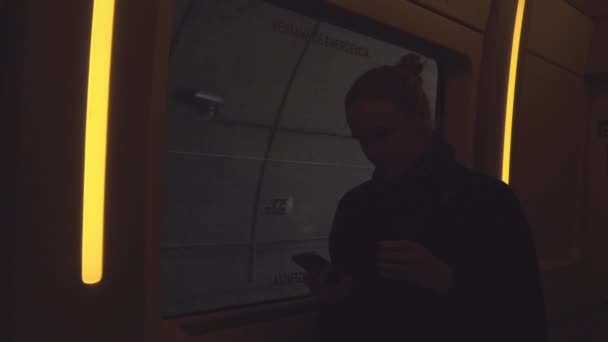 Kvinna på ett pendeltåg som går genom en tunnel — Stockvideo