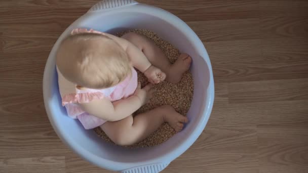 Niedliche Baby-Mädchen in einer runden blauen Wanne 1 — Stockvideo