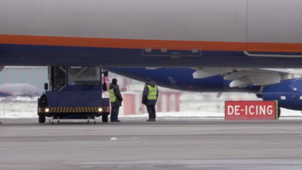 Trabajadores que se preparan para descongelar un avión a reacción — Vídeo de stock