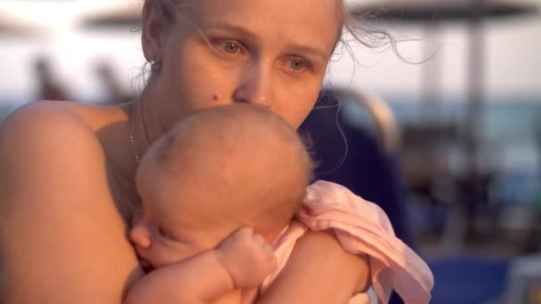 Mãe com bebê na praia ao pôr do sol — Vídeo de Stock