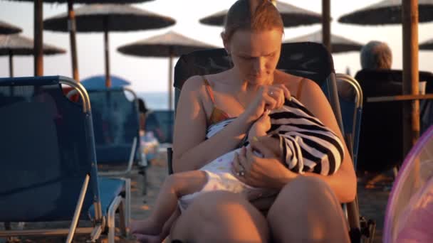 Vrouw borstvoeding baby op het strand — Stockvideo