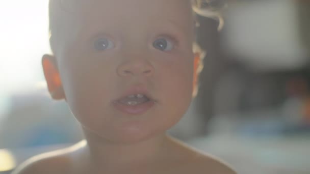 En närbild av en lekfull baby flickor ansikte — Stockvideo