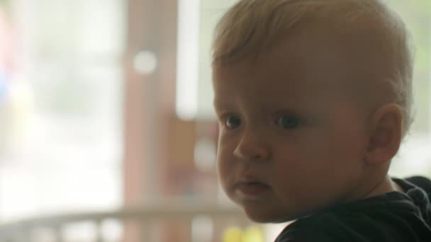 Un primer plano de la cara de una niña que está mirando cuidadosamente a la distancia — Vídeo de stock