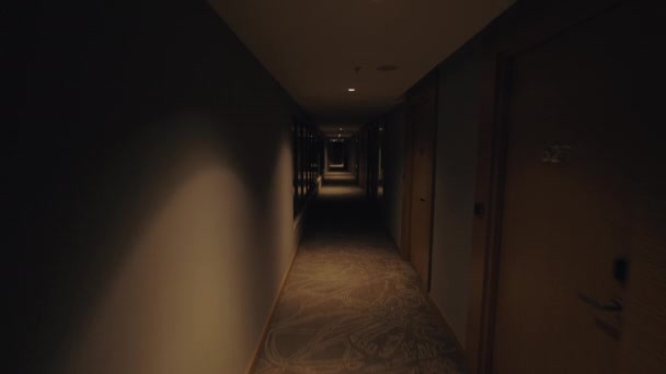 Man wandelend door gang van het hotel en te roepen de lift — Stockvideo