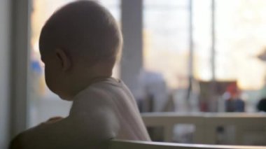 Beşik içinde duran iri mavi gözlü tatlı çocuk