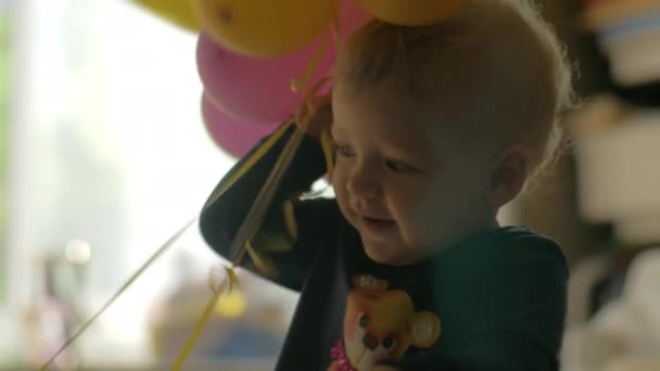 Однорічна дівчинка з повітряними кулями — стокове відео