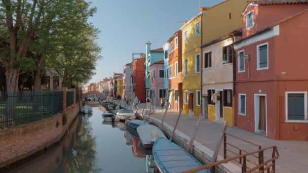 Uferstraße mit bunt bemalten Häusern und spazierenden Menschen. burano, italien — Stockvideo