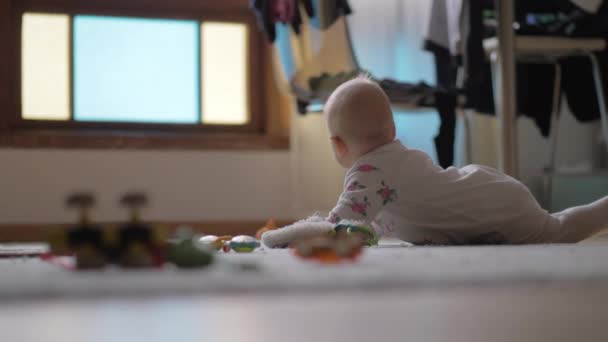 Baby-Mädchen krabbelt mit Spielzeug auf dem Boden — Stockvideo