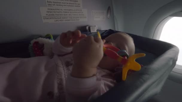 Bambina attiva che vola in aereo in una speciale culla — Video Stock