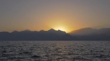 Dağlar ve günbatımı ile deniz manzarası