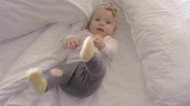 Güzel mavi gözlü bebek kız yatakta yay ile
