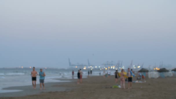 Vista nocturna de la playa con gente, desenfoque — Vídeos de Stock