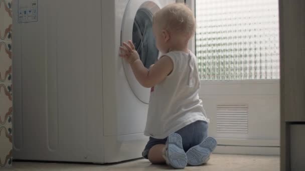 Nieuwsgierig klein kind te kijken naar wasmachine thuis — Stockvideo