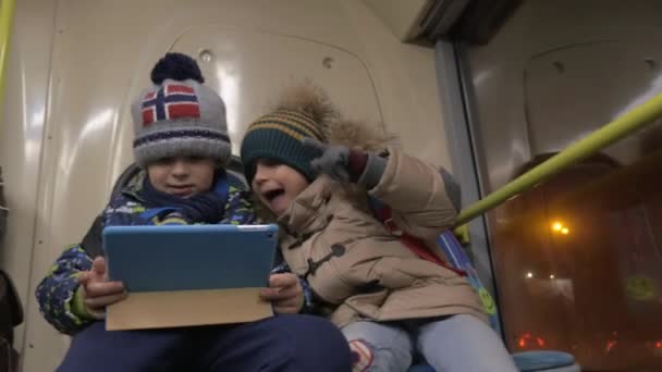 Kinderen spelen touch pad games op de bus — Stockvideo