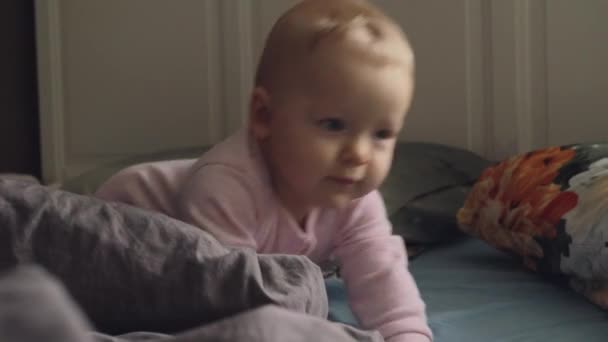 Actieve glimlachende baby meisje op het bed thuis — Stockvideo