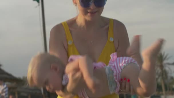 Мама и малышка прекрасно проводят время на пляже — стоковое видео