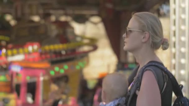 Mutter mit Baby spaziert auf Jahrmarkt — Stockvideo