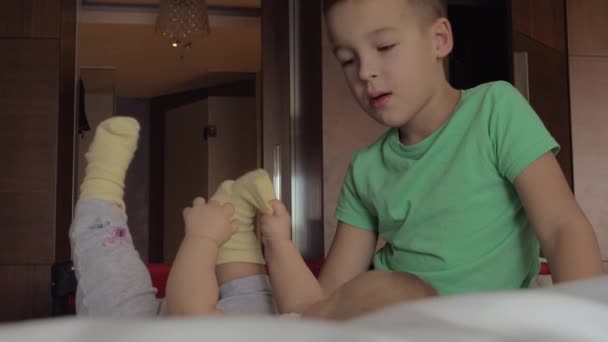 Мальчик любит смотреть на младшую сестру — стоковое видео