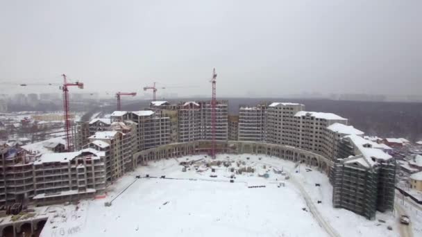 O vedere aeriană a unei construcții de clădiri cu mai multe etaje în zăpadă — Videoclip de stoc